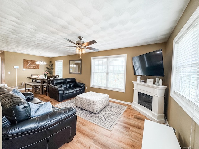 60 Sachem Dr Unit 60, Plainfield, CT 06374 - living room featuring ceiling fan, a glass covered fireplace, light wood-style flooring, and a chandelier
