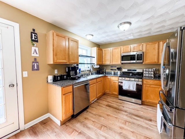60 Sachem Dr Unit 60, Plainfield, CT 06374 - kitchen featuring appliances with stainless steel finishes, light wood-type flooring, and dark stone counters