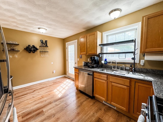 60 Sachem Dr Unit 60, Plainfield, CT 06374 - kitchen featuring stainless steel appliances, brown cabinets, light wood-style floors, dark stone counters, and a textured ceiling