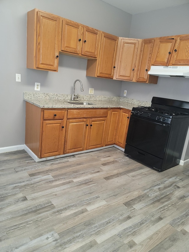 41 Mahl Ave, Hartford, CT 06154 - kitchen with black range with gas cooktop, under cabinet range hood, light stone countertops, and light wood-style flooring