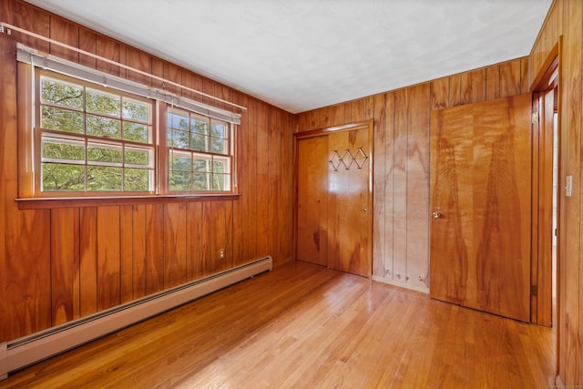 233 Mountain Rd, Cheshire, CT 06410 - unfurnished bedroom featuring baseboard heating, wood finished floors, wooden walls, and a closet