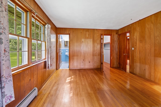 233 Mountain Rd, Cheshire, CT 06410 - spare room with baseboard heating, wood finished floors, healthy amount of natural light, and wooden walls