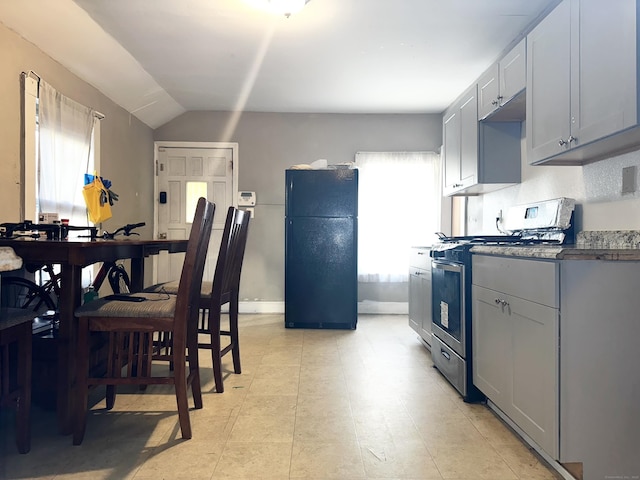 98 Sylvan Ave, New Haven, CT 06519 - kitchen featuring freestanding refrigerator, stainless steel range with gas stovetop, lofted ceiling, and gray cabinets