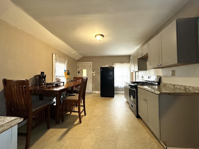 98 Sylvan Ave, New Haven, CT 06519 - kitchen with stainless steel gas range oven, freestanding refrigerator, and vaulted ceiling