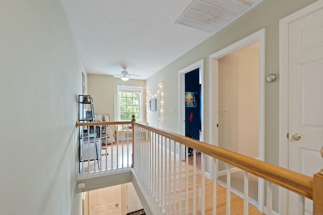 11 Adam Dr, Newington, CT 06111 - hall with an upstairs landing, light wood-style flooring, and a textured ceiling