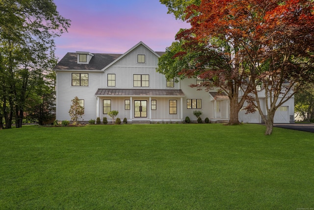 52 Garibaldi Ln, New Canaan, CT 06840 - modern farmhouse style home with a standing seam roof, board and batten siding, a front lawn, and a metal roof