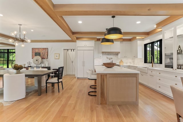 52 Garibaldi Ln, New Canaan, CT 06840 - kitchen featuring healthy amount of natural light, light countertops, tasteful backsplash, white cabinetry, and beamed ceiling