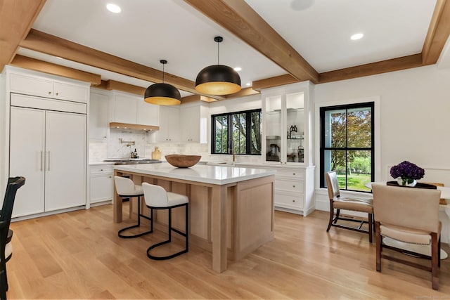 52 Garibaldi Ln, New Canaan, CT 06840 - kitchen featuring beamed ceiling, decorative backsplash, light wood finished floors, light countertops, and white cabinets