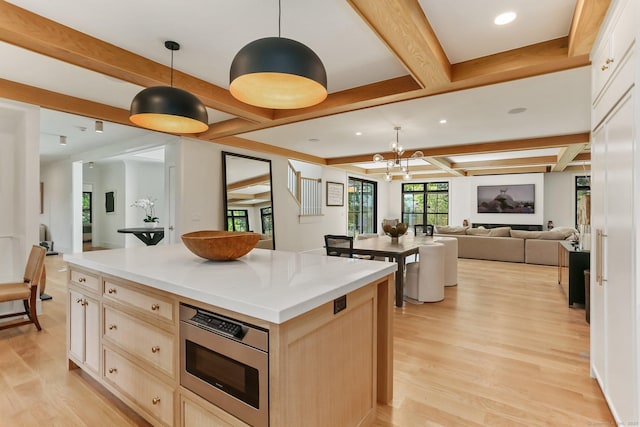 52 Garibaldi Ln, New Canaan, CT 06840 - kitchen featuring stainless steel microwave, light wood-style flooring, light brown cabinetry, beam ceiling, and a kitchen island