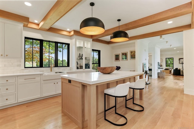 52 Garibaldi Ln, New Canaan, CT 06840 - kitchen with a kitchen island, beamed ceiling, white cabinets, tasteful backsplash, and light countertops