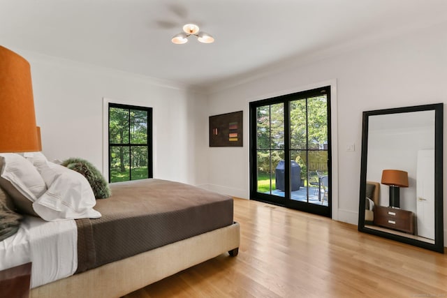 52 Garibaldi Ln, New Canaan, CT 06840 - bedroom with ornamental molding, wood finished floors, multiple windows, and access to outside
