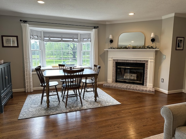 311 Georgetown Dr Unit 311, Glastonbury, CT 06033 - dining area with ornamental molding, a brick fireplace, wood finished floors, a textured ceiling, and recessed lighting