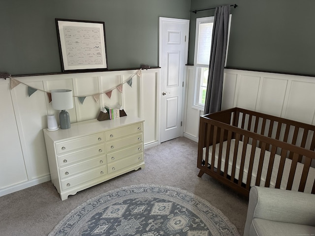 311 Georgetown Dr Unit 311, Glastonbury, CT 06033 - bedroom featuring light colored carpet, a decorative wall, wainscoting, and a crib