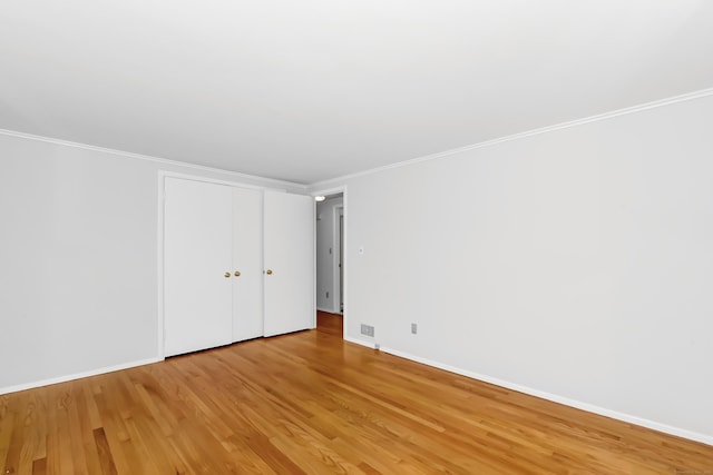 103 Colonial Dr, Fairfield, CT 06824 - unfurnished bedroom with light wood-style flooring, crown molding, and a closet
