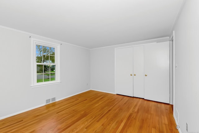103 Colonial Dr, Fairfield, CT 06824 - unfurnished bedroom with light wood-type flooring, ornamental molding, and a closet