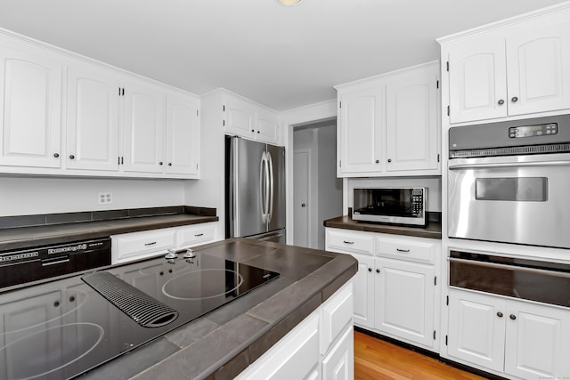 103 Colonial Dr, Fairfield, CT 06824 - kitchen featuring appliances with stainless steel finishes, dark countertops, a warming drawer, and white cabinets