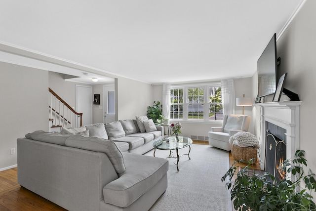 103 Colonial Dr, Fairfield, CT 06824 - living area featuring wood finished floors, stairway, and a lit fireplace