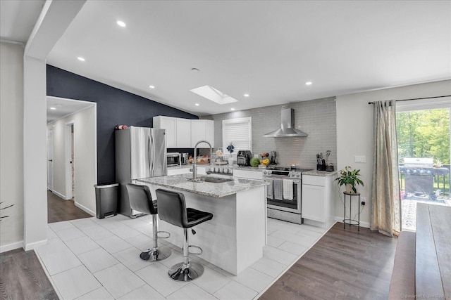 202A Hartford Pike, Foster, Rhode Island, RI 02825 - kitchen featuring stainless steel appliances, wall chimney exhaust hood, white cabinets, a skylight, and recessed lighting