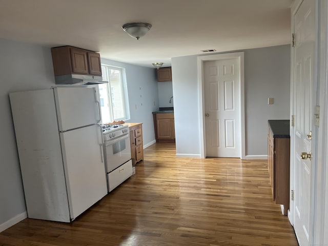 959 First Ave, West Haven, CT 06516 - kitchen featuring white appliances, dark countertops, wood finished floors, and under cabinet range hood