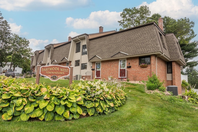 253 W St Apt B, Southington, CT 06479 - back of house featuring brick siding, roof with shingles, a chimney, and a yard