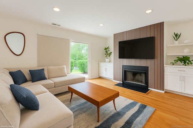 267 Melba St Apt D10, Milford, CT 06460 - living room with light wood finished floors, a fireplace with flush hearth, built in features, and recessed lighting