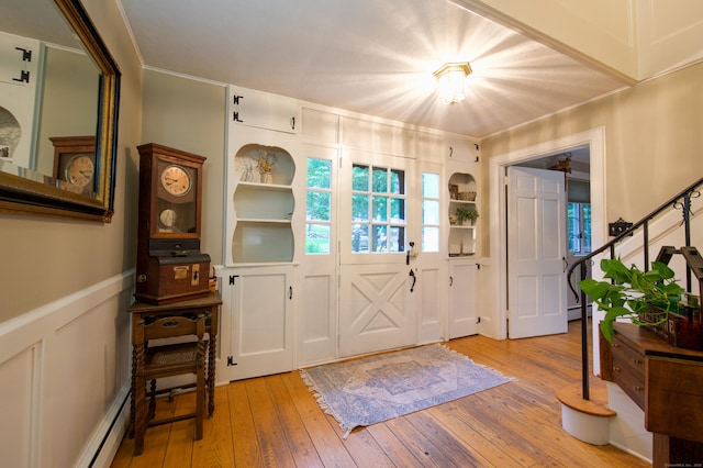 593 Northfield Rd, Watertown, CT 06795 - foyer featuring light wood-type flooring, a baseboard radiator, a wainscoted wall, crown molding, and stairway