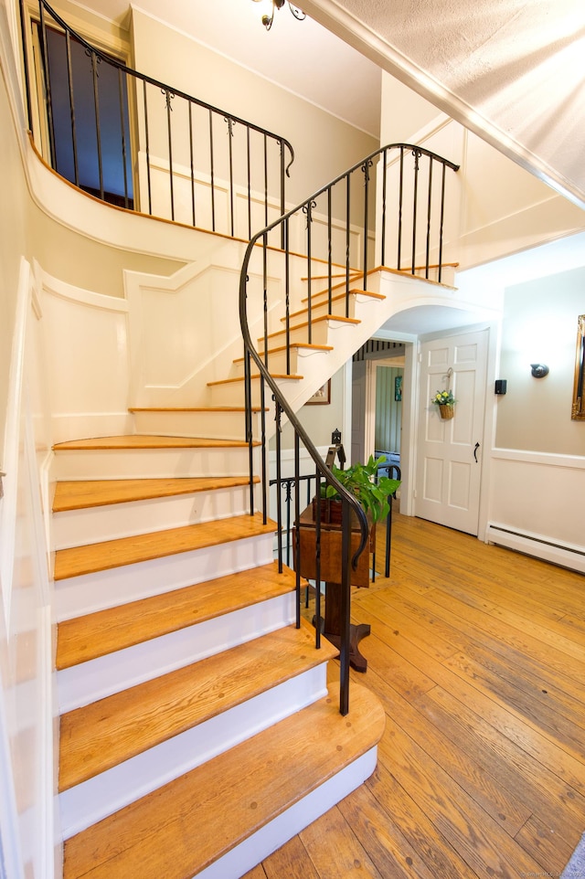 593 Northfield Rd, Watertown, CT 06795 - stairs featuring a baseboard radiator and hardwood / wood-style flooring