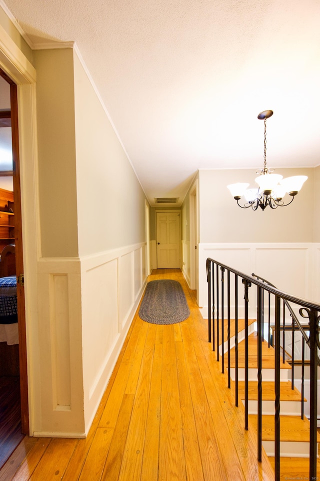 593 Northfield Rd, Watertown, CT 06795 - hall featuring a chandelier, light wood finished floors, a decorative wall, a wainscoted wall, and crown molding