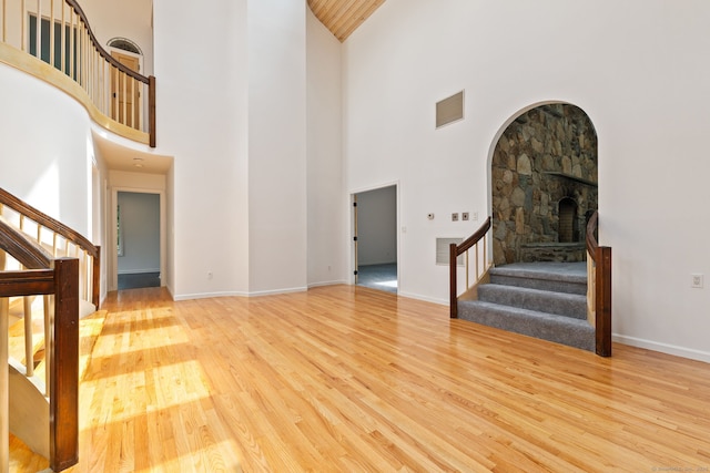 202 High Wood Dr, Glastonbury, CT 06073 - unfurnished living room featuring stairway, high vaulted ceiling, wood finished floors, and arched walkways