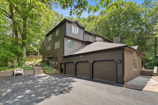 202 High Wood Dr, Glastonbury, CT 06073 - view of front of home with asphalt driveway, an attached garage, a chimney, and a shingled roof