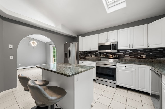 19 Peach Tree Hill Ave, Ledyard, CT 06339 - kitchen with stainless steel appliances, arched walkways, lofted ceiling, light tile patterned flooring, and backsplash