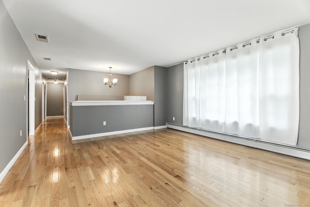 221 Griffin Rd, Suffield, CT 06093 - spare room with a baseboard radiator, a chandelier, and light wood-style floors