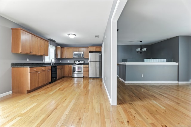221 Griffin Rd, Suffield, CT 06093 - kitchen featuring stainless steel appliances, a chandelier, light wood-style floors, dark countertops, and brown cabinetry