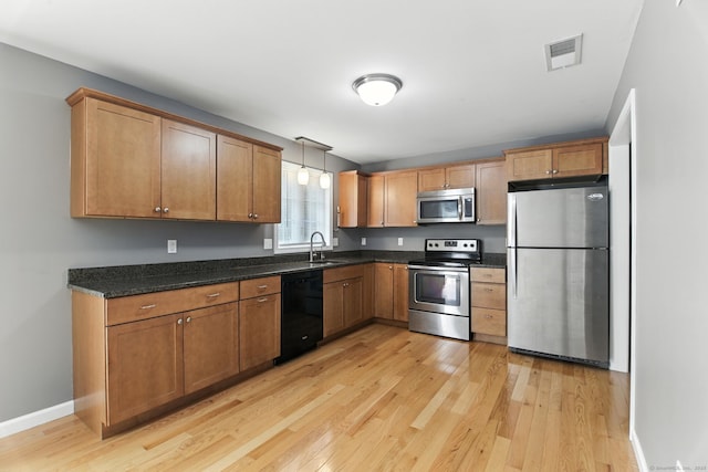 221 Griffin Rd, Suffield, CT 06093 - kitchen with appliances with stainless steel finishes, light wood-style floors, hanging light fixtures, and dark stone counters