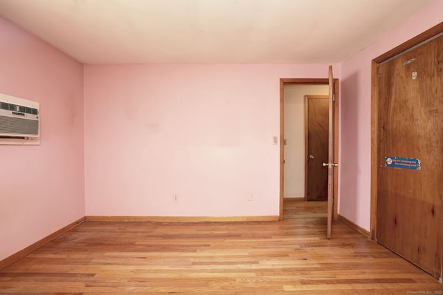 68 Highland Ave, East Haven, CT 06513 - empty room with light wood-style floors and a wall unit AC