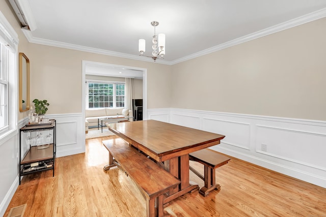 84 Edison Ave, Fairfield, CT 06825 - dining room featuring ornamental molding, a chandelier, light wood-style floors, a wainscoted wall, and a decorative wall