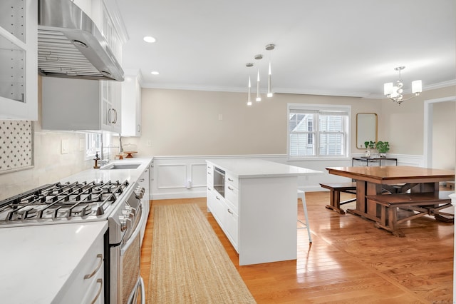 84 Edison Ave, Fairfield, CT 06825 - kitchen featuring range hood, gas stove, ornamental molding, light countertops, and white cabinets