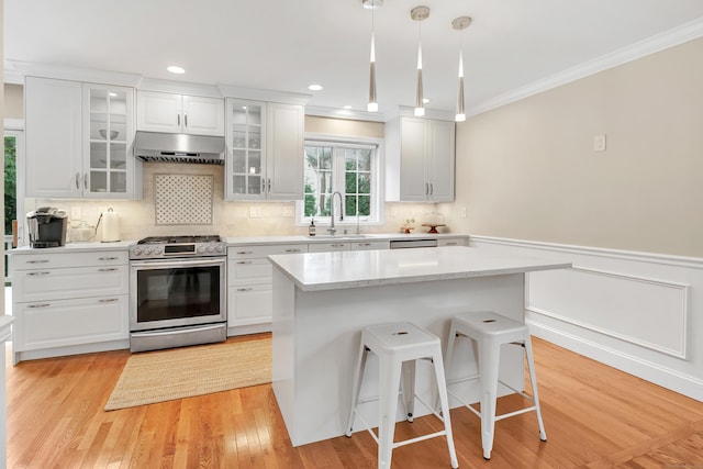 84 Edison Ave, Fairfield, CT 06825 - kitchen featuring appliances with stainless steel finishes, under cabinet range hood, ornamental molding, white cabinets, and tasteful backsplash