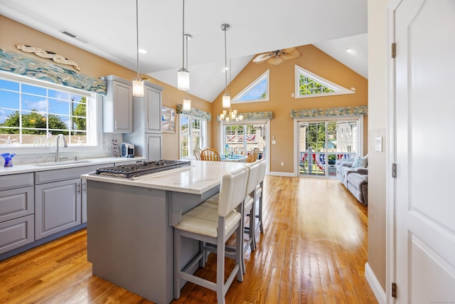79 Orland St, Milford, CT 06460 - kitchen featuring gray cabinets, a breakfast bar area, stainless steel gas stovetop, a center island, and ceiling fan