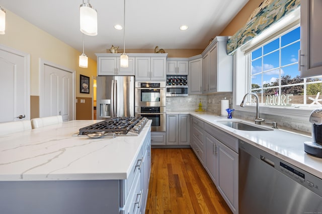 79 Orland St, Milford, CT 06460 - kitchen with appliances with stainless steel finishes, gray cabinetry, tasteful backsplash, wood finished floors, and hanging light fixtures