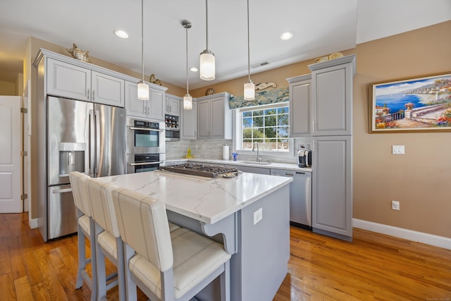 79 Orland St, Milford, CT 06460 - kitchen with appliances with stainless steel finishes, light wood-style floors, a center island, light stone counters, and recessed lighting