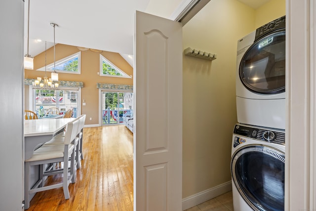 79 Orland St, Milford, CT 06460 - laundry area featuring stacked washing machine and dryer, a chandelier, and light wood-style floors