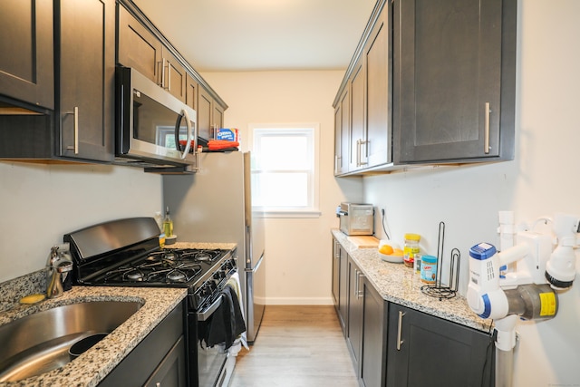 107 Dwight St, New Britain, CT 06051 - kitchen with stainless steel microwave, black gas range, light wood-type flooring, and light stone counters