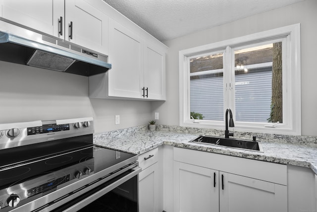 226 E Main St Apt 4, Bristol, CT 06010 - kitchen with stainless steel electric range oven, exhaust hood, white cabinetry, a textured ceiling, and light stone counters