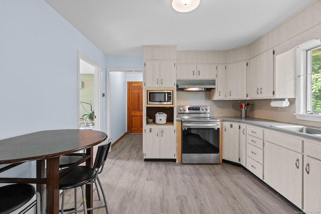 61 Mansfield Rd, New London, CT 06320 - kitchen featuring appliances with stainless steel finishes, under cabinet range hood, light wood finished floors, and light countertops