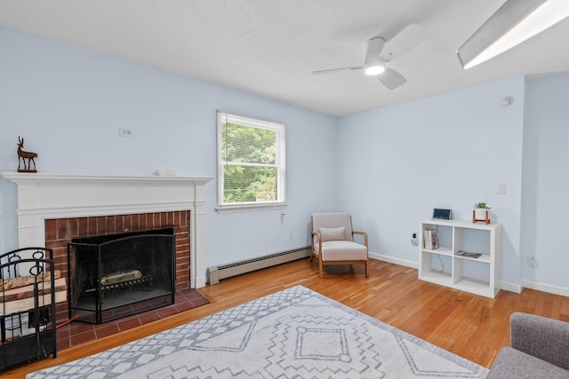 61 Mansfield Rd, New London, CT 06320 - sitting room with baseboard heating, wood finished floors, ceiling fan, a fireplace, and a textured ceiling