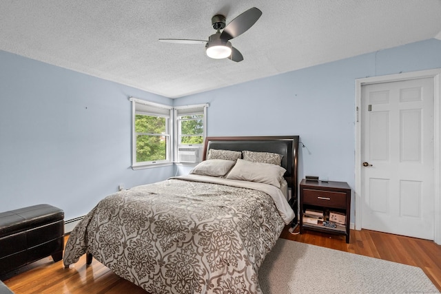 61 Mansfield Rd, New London, CT 06320 - bedroom with wood finished floors, a textured ceiling, cooling unit, ceiling fan, and baseboard heating