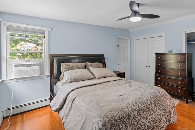 61 Mansfield Rd, New London, CT 06320 - bedroom with wood finished floors, a closet, a baseboard radiator, ceiling fan, and a textured ceiling