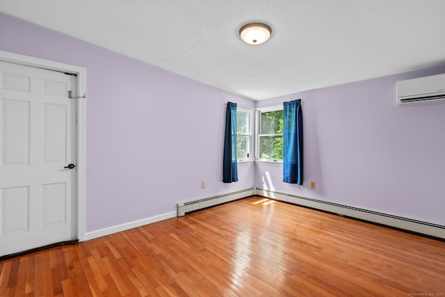 61 Mansfield Rd, New London, CT 06320 - empty room featuring a wall mounted AC, wood finished floors, and a baseboard radiator