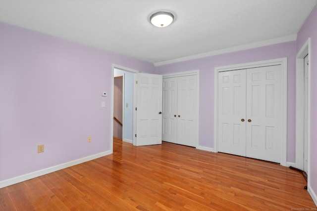 61 Mansfield Rd, New London, CT 06320 - unfurnished bedroom featuring multiple closets and light wood-style floors
